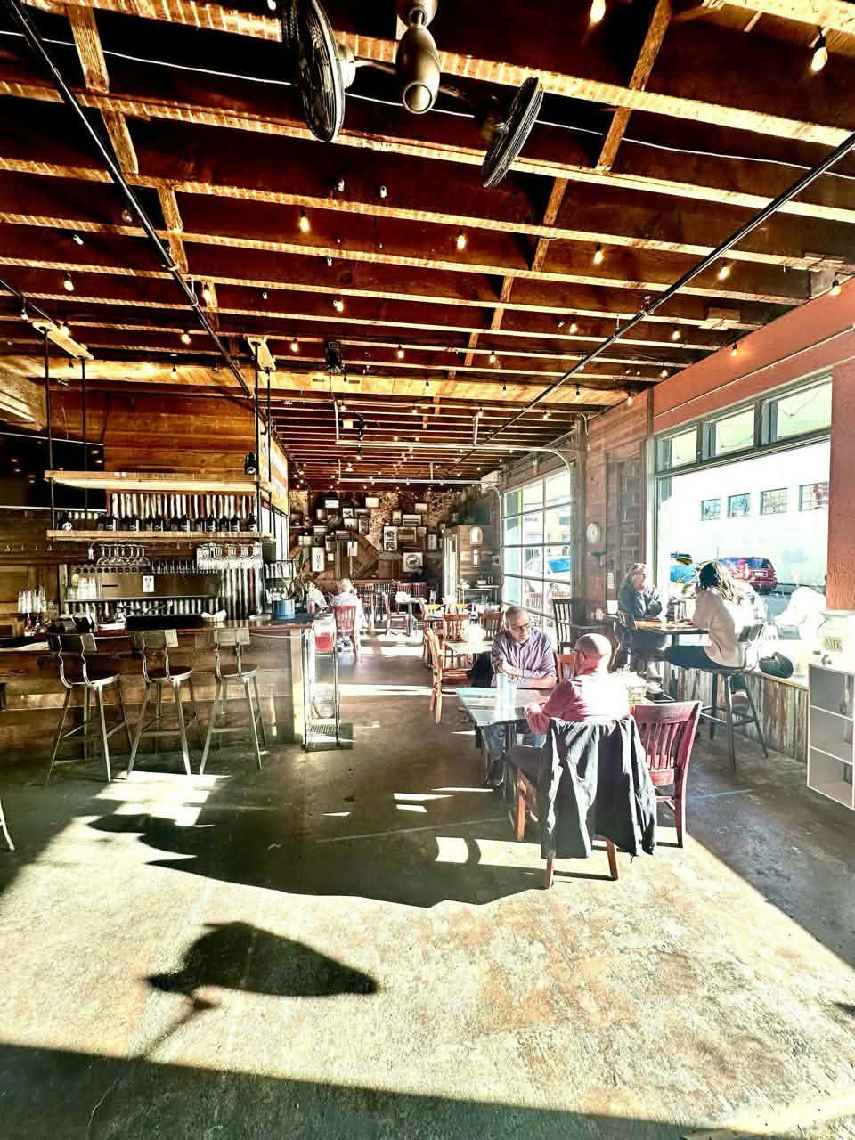 Picture inside of the eatery with people eating and the sun shining through the windows
